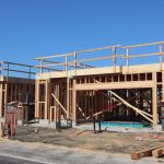 Residência em construção com estrutura de madeira aparente.