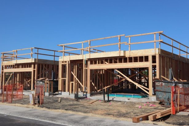 Residência em construção com estrutura de madeira aparente.