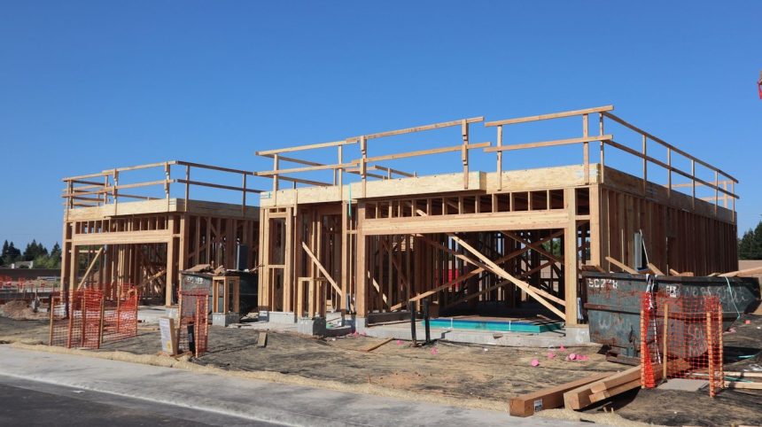 Residência em construção com estrutura de madeira aparente.